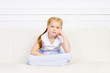 © Acronym - Beautiful Little Girl Sitting On Sofa. Family, Home, Love Concept.