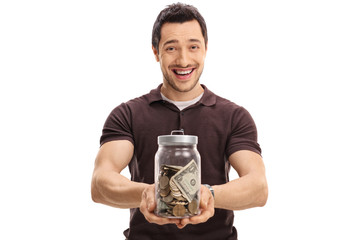 Wall Mural - Joyful guy holding a jar full of money