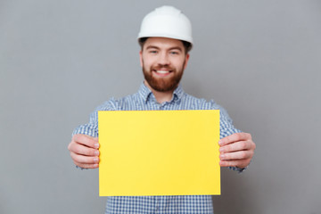 Wall Mural - Bearded man builder showing copyspace blank to camera