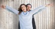 Portrait of happy couple standing with arms outstretched