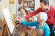 © Viacheslav Yakobchuk - Delighted artist helping elderly woman in painting studio