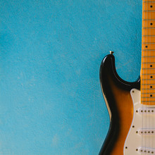 Vintage Sunburst Color Guitar With Blue Cemennt Background.