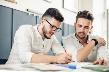 two men designers looking at plans