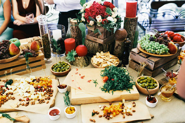 Wall Mural - Table with snacks, fruits and cheese on large beige table