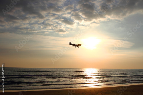 Plakat ultralekki samolot latający nad morzem o zachodzie słońca