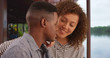 © Mark Adams - Millennial black man and woman talk next to the picturesque water