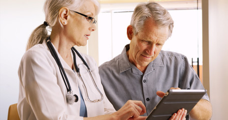 woman senior doctor expressing health concerns with elderly man patient