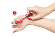 Woman applying red nail polish her nails manicure on white background isolated