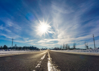 Asphalt road in snowy winter on beautiful frosty sunny day. Journey, trip, trave