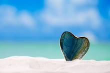 Green Glass Heart On White Sand Beach,