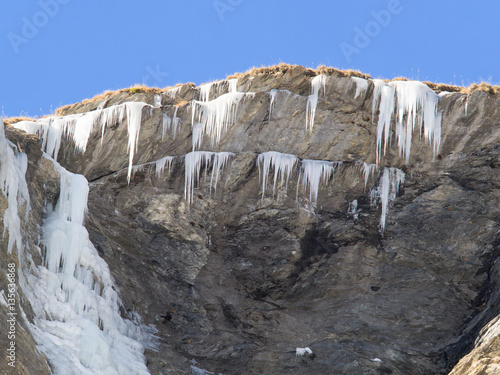 Fotografia, Obraz Ice stalactites and frozen waterfall on a rock face
