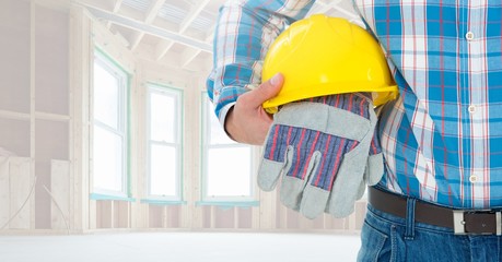 Construction worker holding hard hat and gloves