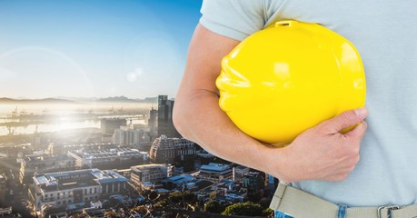 Poster - Handyman holding hard hat against cityscape