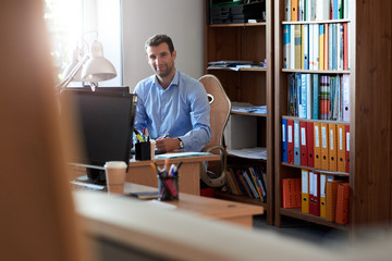 Smiling businessman working at his desk in an office