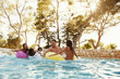 © Monkey Business - Group Of Friends On Inflatables In Outdoor Pool