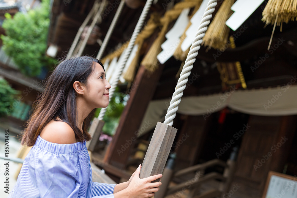 Woman holding the rope in Japanese temple