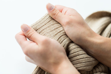 close up of hands with knitted clothing item