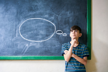 Wall Mural - Boy Student Leaning On Blackboard And Thinking In Classroom