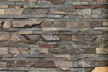 Wall Mural - background decorative wall built of brown stone closeup