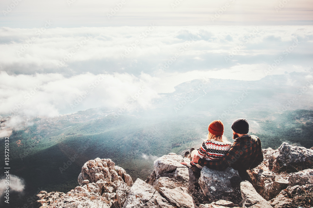 Couple travelers Man and Woman sitting on cliff relaxing mountains and clouds aerial view  Love and Travel happy emotions Lifestyle concept. Young family traveling active adventure vacations - obrazy, fototapety, plakaty 