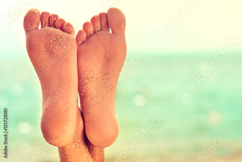 Zdjęcie XXL Idealne czyste stopy kobiece z morskim piaskiem na plaży. Pielęgnacja zdroju, peelingu i stóp. Masaż stóp .
