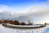 Fototapeta  - Samochód dostawczy zimą na drodze w górach, człowiek na szczycie góry.