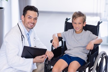 Canvas Print - Portrait of smiling doctor and disable boy in corridor