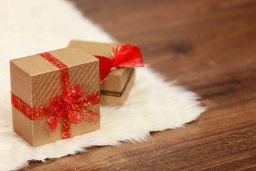 Two golden gift boxes with red ribbon bow