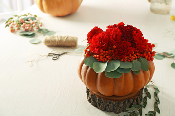 Sticker - Beautiful composition of red flowers, berries and pumpkin on white table