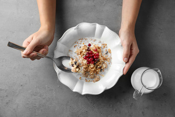 Wall Mural - Female hands holding bowl with healthy breakfast, closeup