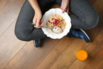 Wall Mural - Woman sitting on the floor with healthy breakfast