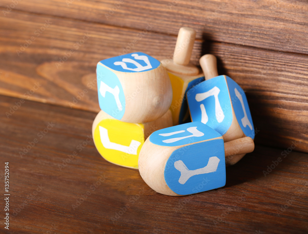 Dreidels for Hanukkah on wooden background