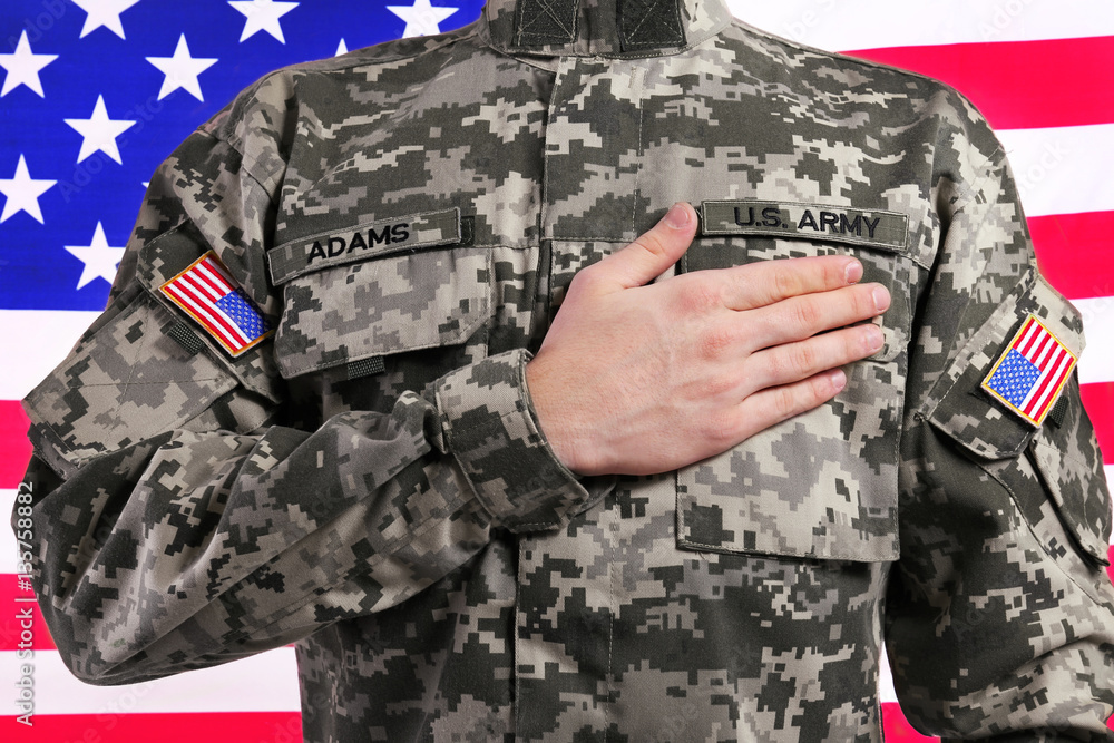 Soldier with hand on heart against USA flag