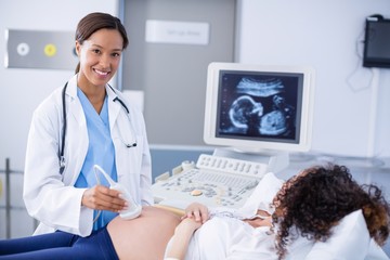 Doctor doing ultrasound scan for pregnant woman