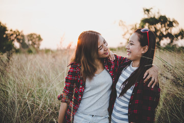 Close up of two girls. Close friends in field with sunset.