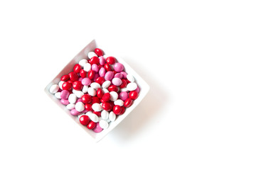 Colorful red, white, pink coated Valentine candy in a bowl isola