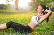 © Bojan - Portrait of a young woman doing some abs outdoors.