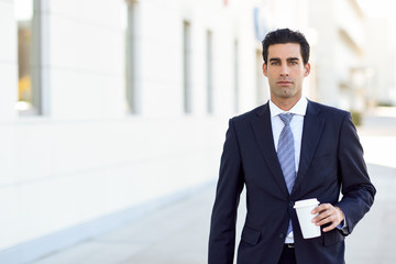 Businessman drinking coffee to go with a take away cup