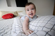 © javiindy - Baby girl lying on her parents bed with funny expression