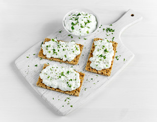 Wall Mural - Homemade Crispbread toast with Cottage Cheese and parsley on white wooden board.