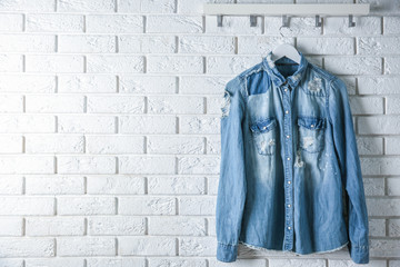 Wall Mural - Denim shirt hanging on brick wall