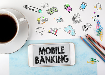Wall Mural - Mobile banking. Mobile phone and coffee cup on a white office desk.