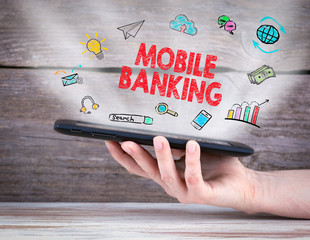 Wall Mural - Mobile banking. Tablet computer in the hand. Old wooden background.