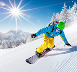 Snowboarder going downhill in high mountains