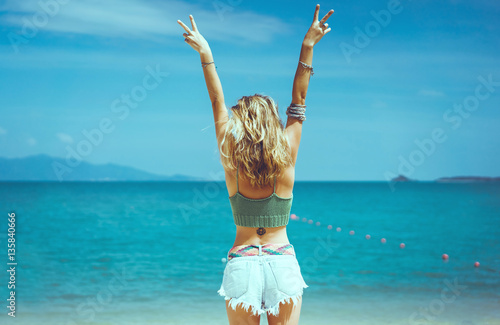 Fotografie, Obraz pretty woman posing in the sea, blue sky, hair wild, victory hand up!, outdoor p