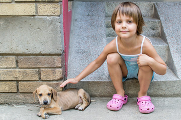 little girl cuddle a puppy 