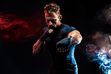 studio portrait of fighting muscular man in smoke