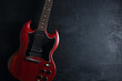 Top view of red electric guitar on dark wooden background