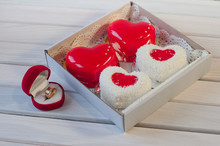 Four Heart Shaped Cakes In Box And Wedding Ring On Table