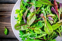 Fresh Salad With Mixed Greens On Wooden Background Closeup
